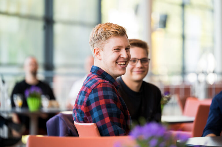 Ein junger Mann bei einer Versammlung, der lacht